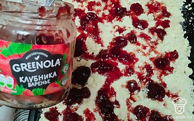 На противень для выпечки выложите половину рубленого теста. Сверху полейте клубничным вареньем.