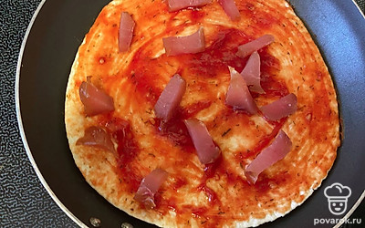 Карпаччо нарежьте мелко и выложите равномерно по пицце.