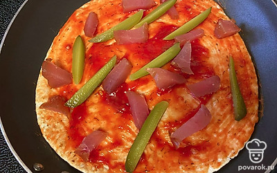 Огурец нарежьте произвольно и тоже выложите на пиццу. Можете взять соленый или свежий, на ваше усмотрение.