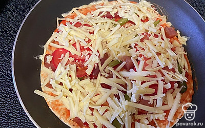 Сыр натрите на терке. Посыпьте им пиццу сверху.