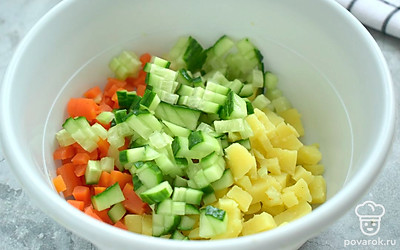Свежий огурчик тоже нарежьте для оливье кубиками. Добавьте нарезку к картошке и моркови.