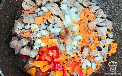 Лук и болгарский перец нарежьте небольшими кусочками. Морковь натрите на терке, добавьте в сковороду к мясу. Обжаривайте все вместе 5 минут.
