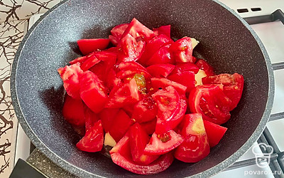 В сковородку выложите сливочное масло. Помидоры очистите от кожуры и нарежьте на крупные куски.