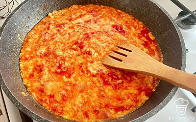 Помидоры варите около 10-15 минут, периодически разминая толкушкой. Влейте яйца и быстро перемешайте.