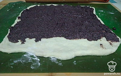 Достаньте готовое тесто и положите в теплое место на 20-30 минут, чтобы оно поднялось. Раскатайте тесто в тонкий квадрат. Так легче будет формировать рулет. Выложите начинку равномерным слоем. С одной стороны оставьте полоску теста без начинки (около 3-4 сантиметров).