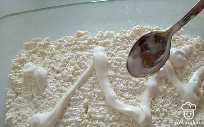 Форму для запекания смажьте сливочным маслом. Творожную массу переложите в форму и разравняйте сверху ложкой. Смажьте тонким слоем сметаны.