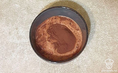 Тесто разделите на 2 равные части. Одну часть теста перелейте в отдельную миску. Добавьте какао и молоко, хорошо размешайте.