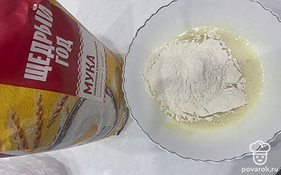 Всыпьте стакан муки и начните замешивать тесто.