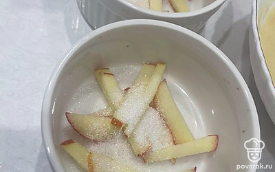 Разложите полоски яблока в формы, присыпьте фрукты сахаром.