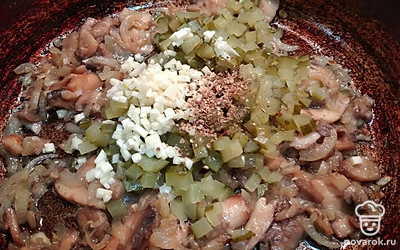 Добавьте нарезанные огурцы, чеснок, смесь перцев и перемешайте. 