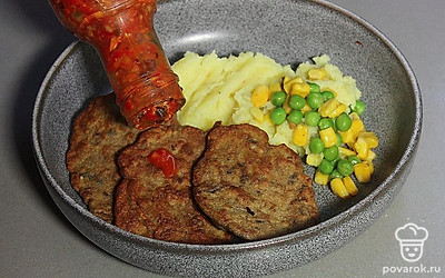 Подавайте оладьи с картофельным пюре, зеленым горошком и кукурузой. Сверху полейте соусом. Можете украсить зеленью по вашему вкусу.