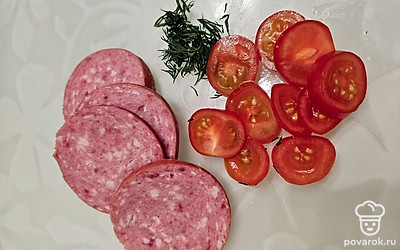 Укроп помойте и мелко нарежьте. Колбасу и помидоры нарежьте слайсами. Корейскую морковь мелко нарежьте. Тесто присыпьте мукой и слегка раскатайте, разрежьте на четыре части. 