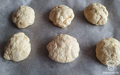 Из этого количества теста получилось 7 достаточно больших колобков. Выложите их на пергамент. Выпекайте при температуре 180-200 градусов в течение 25-30 минут.