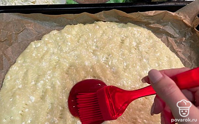 Достаньте из духовки основу для пиццы, смажьте любым любимым соусом.