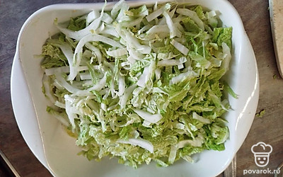 Нарезанную капусту выложите в достаточно глубокое блюдо, так как салат получается пышным.