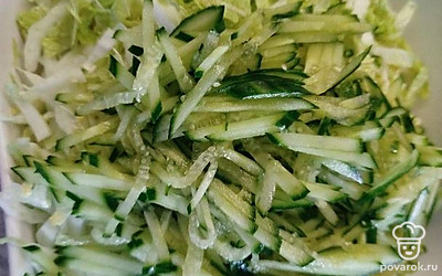 Нарезанные огурцы отправьте в блюдо к капусте.