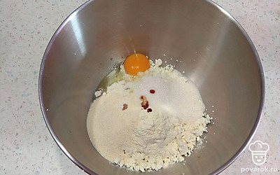 В миске смешайте творог, яйцо, муку, манку и ванилин. Перетрите вилкой все ингредиенты до однородности.