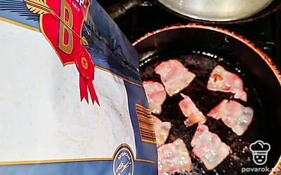 На сковороду выложите копченый бекон. Обжаривайте 3 минуты. 