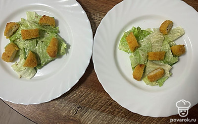 Наггетсы нарежьте на кусочки и выложите на тарелку.