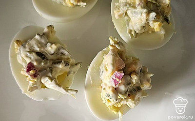 Выложите начинку в яйца.