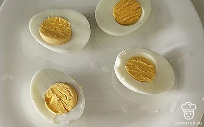 Отварите яйца и разрежьте пополам.