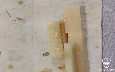 Лаваш разрежьте на прямоугольники. На каждый выложите кусочек сыра и банана. 