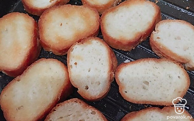 Ломтики багета выложите на разогретую сковороду с небольшим количеством растительного масла. Обжарьте с двух сторон до румяной корочки.