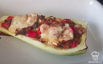 Выложите начинку в кабачок, уберите в разогретую духовку на 30 минут. За 10 минут до готовности посыпьте сыром.