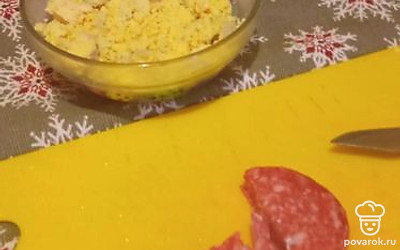 Желток разомните вилкой, колбасу нарежьте мелким кубиком.