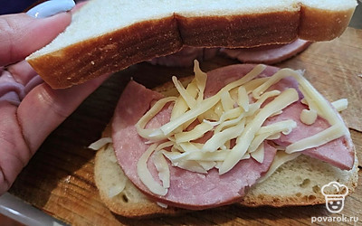 На ломтик хлеба выложите сыр, посыпьте семена льна. Выложите ветчину и снова выложите небольшое количество сыра. Накройте вторым ломтиком хлеба. 