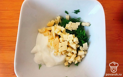 Сыр нарежьте кубиками, зелень измельчите. Смешайте со сметаной. Посолите по вкусу.