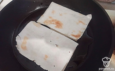 Закройте кусочки лаваша, выложите на горячую сковороду с подсолнечным маслом и обжарьте с двух сторон до румяной корочки (по 2 минуты с каждой стороны).