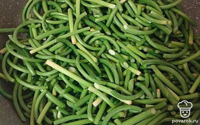 В сковороде разогрейте оливковое масло на среднем огне. Помешивая, обжаривайте стрелки 5–7 минут, пока они не станут мягкими и слегка золотистыми.