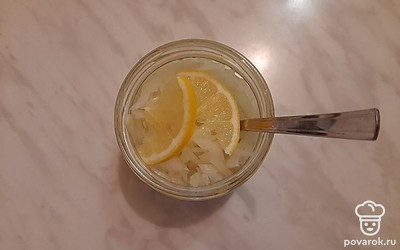 Добавьте 2 дольки лимона и тщательно перемешайте содержимое банки. Затем плотно закройте крышкой. Уберите в холодильник на 40–50 минут.
