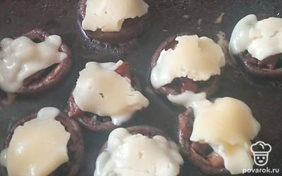 Сверху положите кусочки сыра. Закройте крышкой на 5 минут. Фаршированные грибы готовы! 