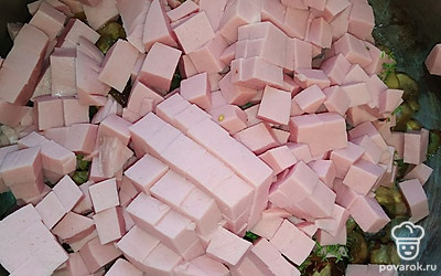 Колбасу нарежьте мелкими кубиками. Выложите к луку и грибам.