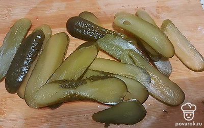 Маринованные огурцы нашинкуйте тонкими полосками. 