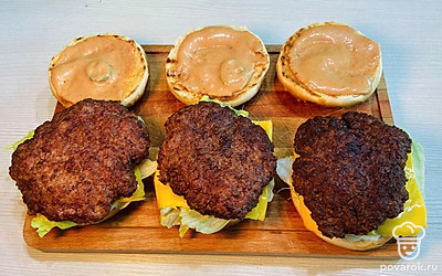 На соус выложите листья салата. Дальше положите ломтик сыра и котлетку.