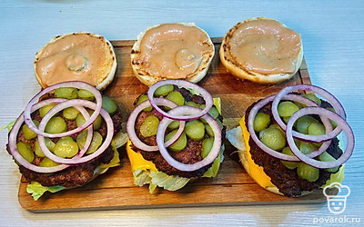 На котлетку выложите огурчики и 3 колечка лука.