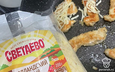 Посыпьте стрипсы сыром.