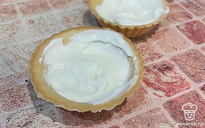 Сыр выложите в тарталетки (заполните до половины).