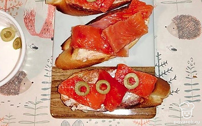 Сформируйте бутерброды. На багет выложите форель, сверху на рыбку положите оливки. Приятного аппетита!