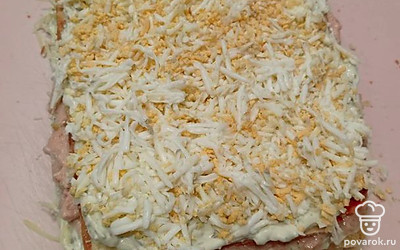 Третий корж приправьте соусом и посыпьте тертым яйцом.