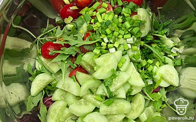 Нарежьте огурец, зеленый лук. Все добавьте в миску с салатом.