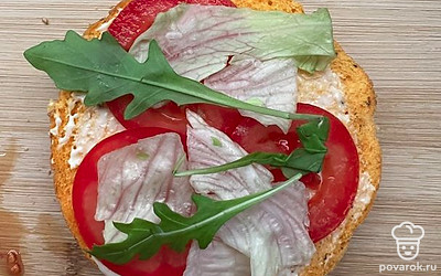 Булочку для бургера разрежьте пополам, смажьте майонезом. Выложите помидор, пару листиков зелени, посолите по вкусу.