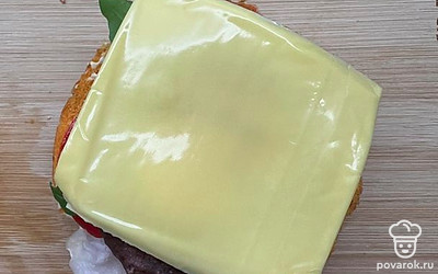 Сверху выложите котлету, по желанию можно добавить ломтик мягкого сыра. И снова закройте булочкой.