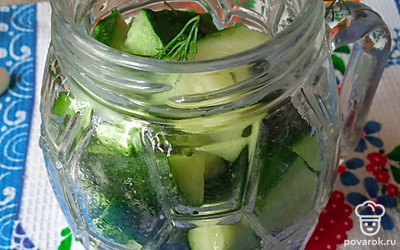 Сложите на дно банки приправу, чеснок и часть укропа. Затем выложите огурцы и сверху разложите оставшийся укроп. 