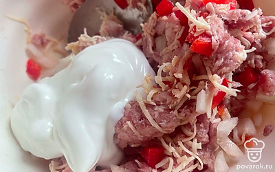 50 грамм сыра натрите на мелкой терке. Смешайте фарш с овощами, сметаной, натертым сыром. Посолите по вкусу. Тщательно все перемешайте. 