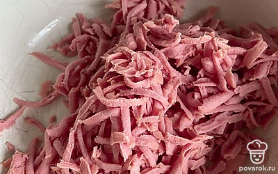 Натираем колбасу на мелкой терке.