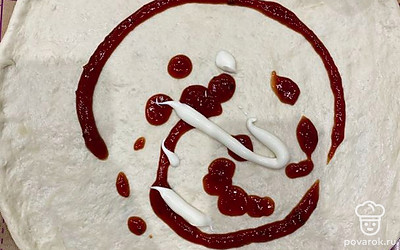 Готовое тесто раскатать кругом, смазать кетчупом и майонезом.